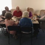 Seniors enjoying conversation and breakfast together in a community setting